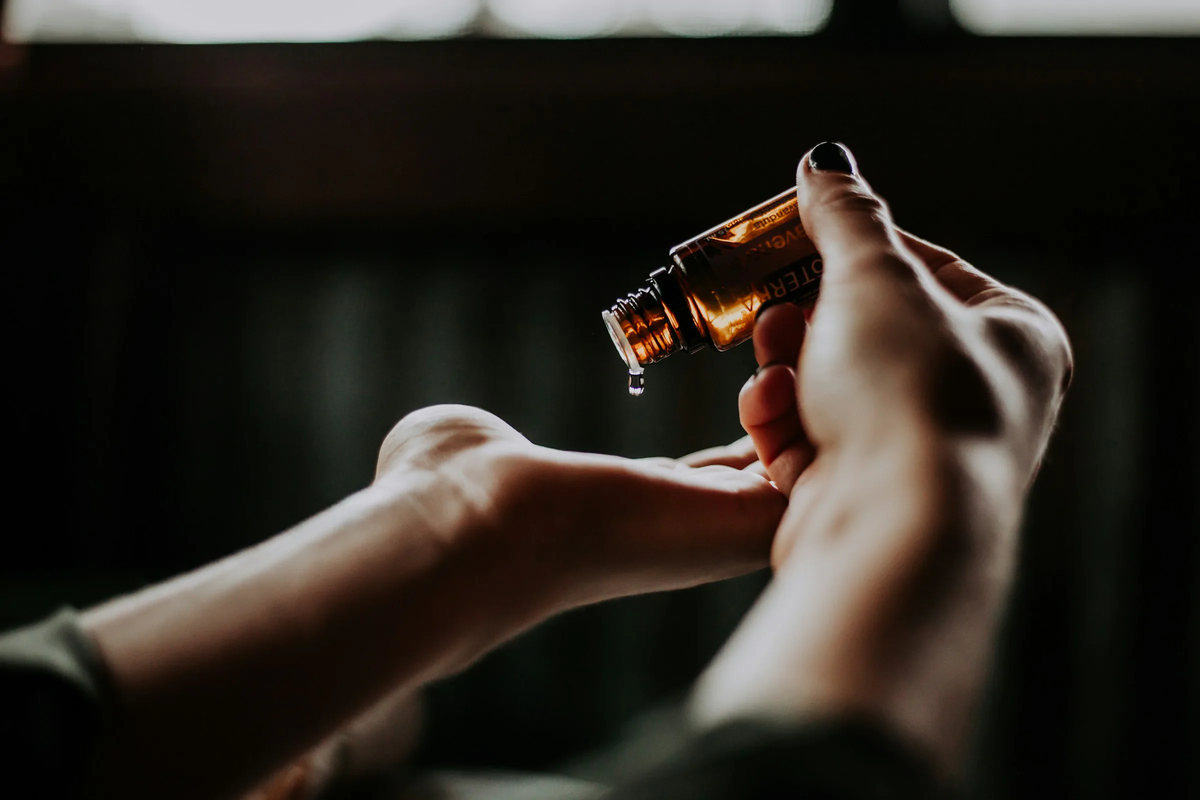 A drop of serum falling onto the back of a hand