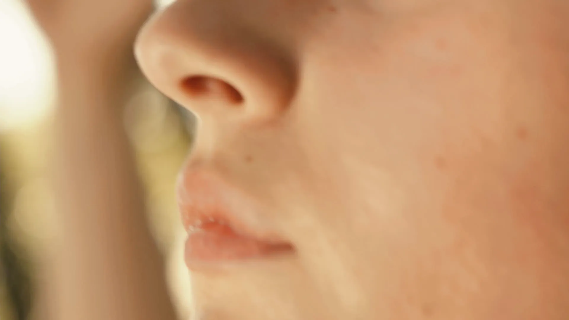 A woman's face in profile, lit gold by the low evening sun